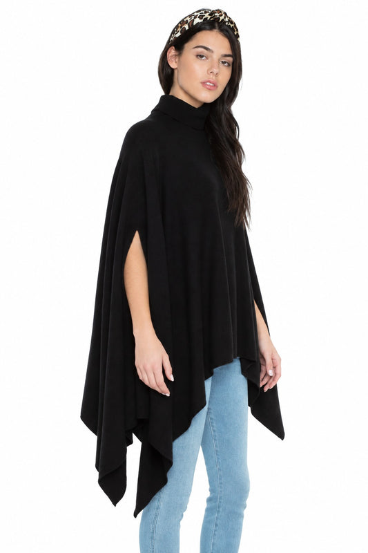 Three-quarter view of the JENNIE LIU black cashmere poncho with cowl neck and open sides, showing the pointed asymmetric hem